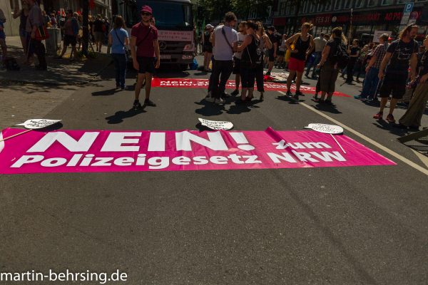 Plakat „NEIN! zum Polizeigesetz NRW“ vor Demonstrationsteilnehmern: Demo gegen das Polizeigesetz in Düsseldorf, Sommer 2018, Foto: martin-bersing.de